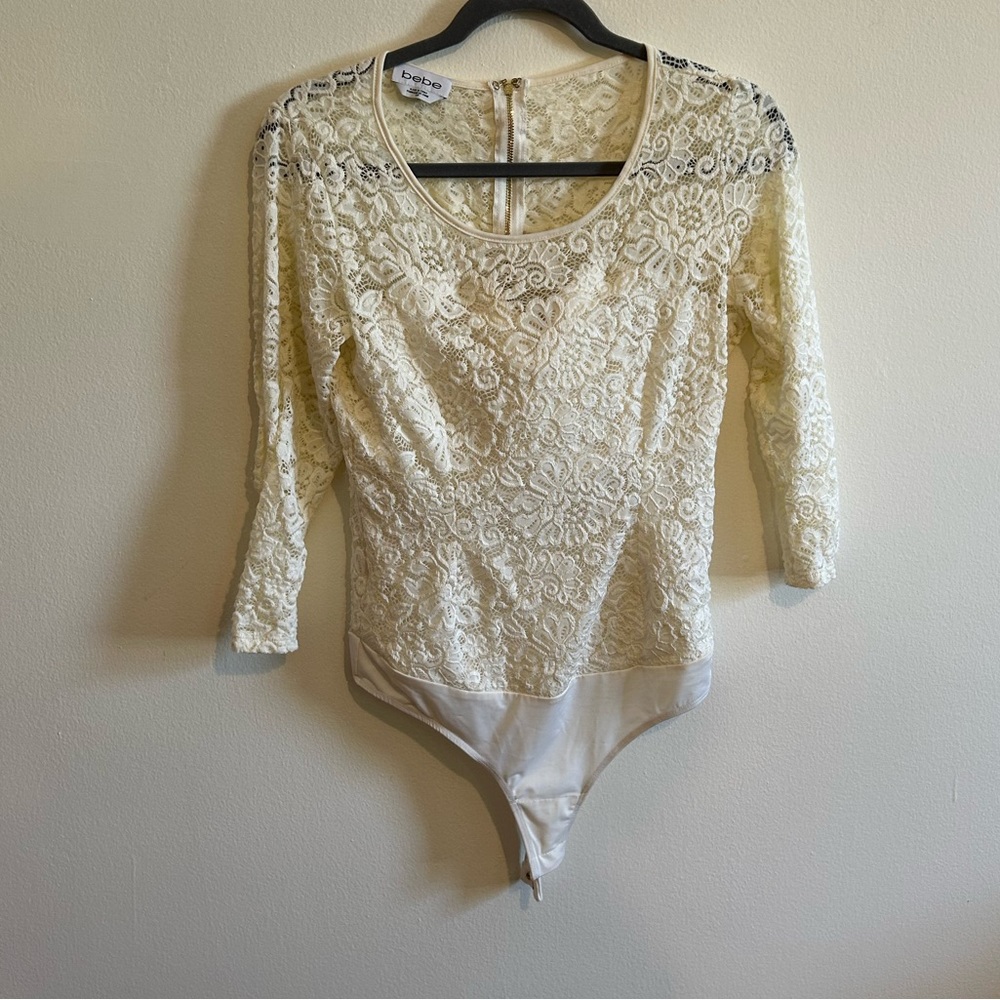 Bebe cream colored lace bodysuit with gold zipper.